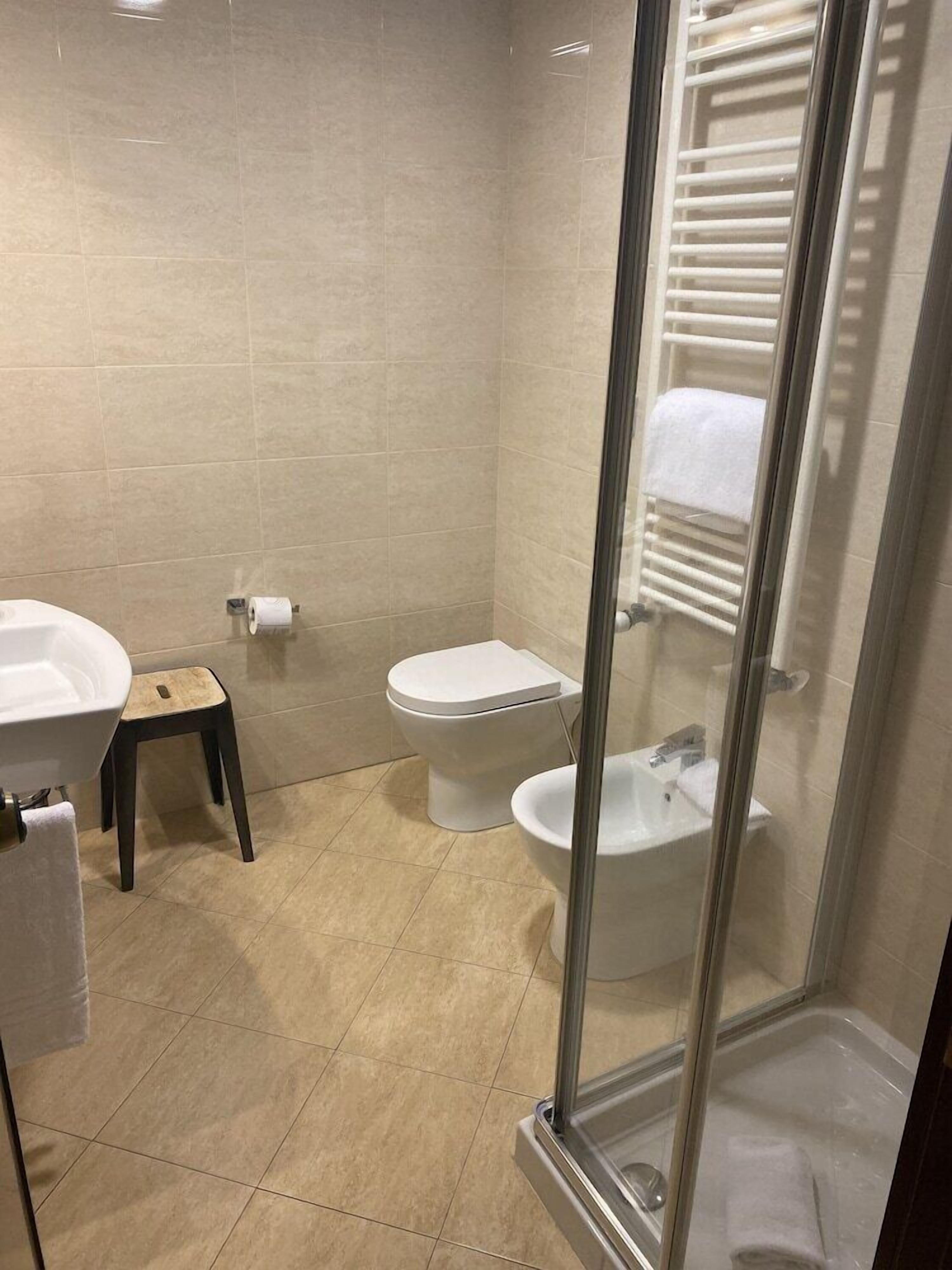 Un baño con inodoro, bidé y lavamanos.