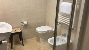 Un baño con inodoro, bidé y lavamanos.