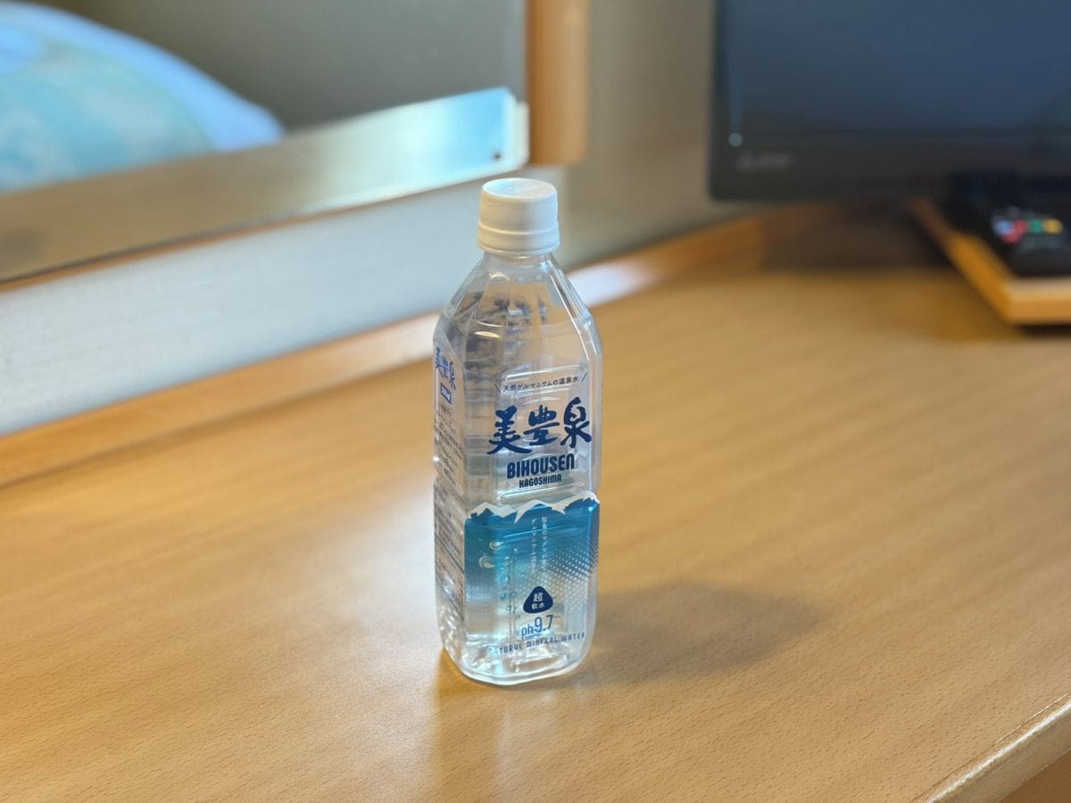 Una botella de agua de plástico transparente sobre una superficie de madera.