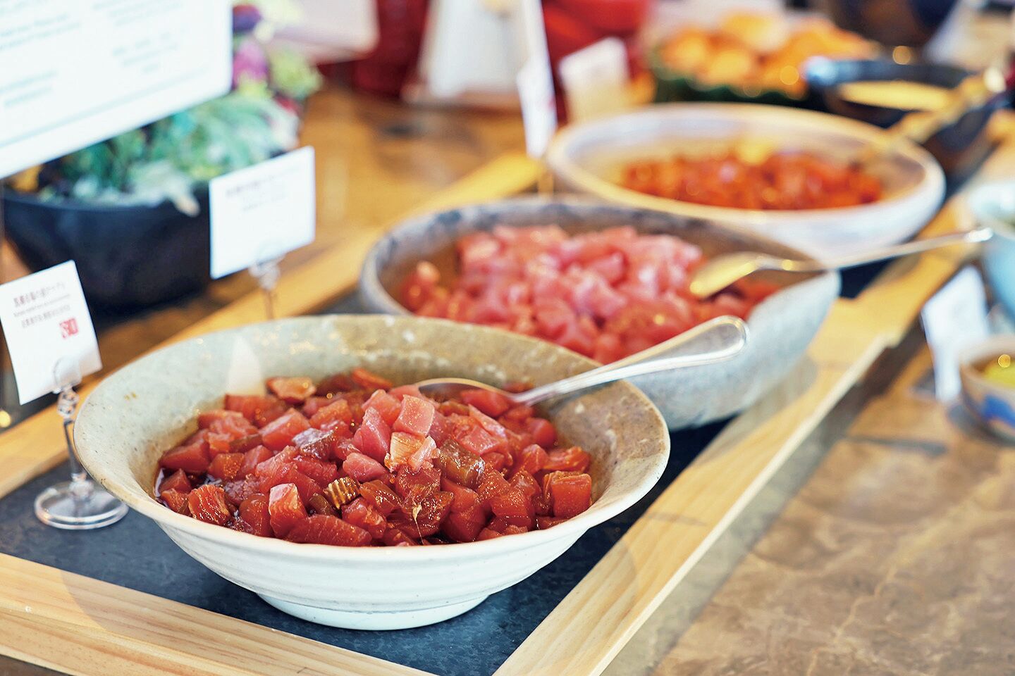 Un buffet con diversi piatti, tra cui una ciotola di carne a cubetti e una ciotola di verdure a cubetti.