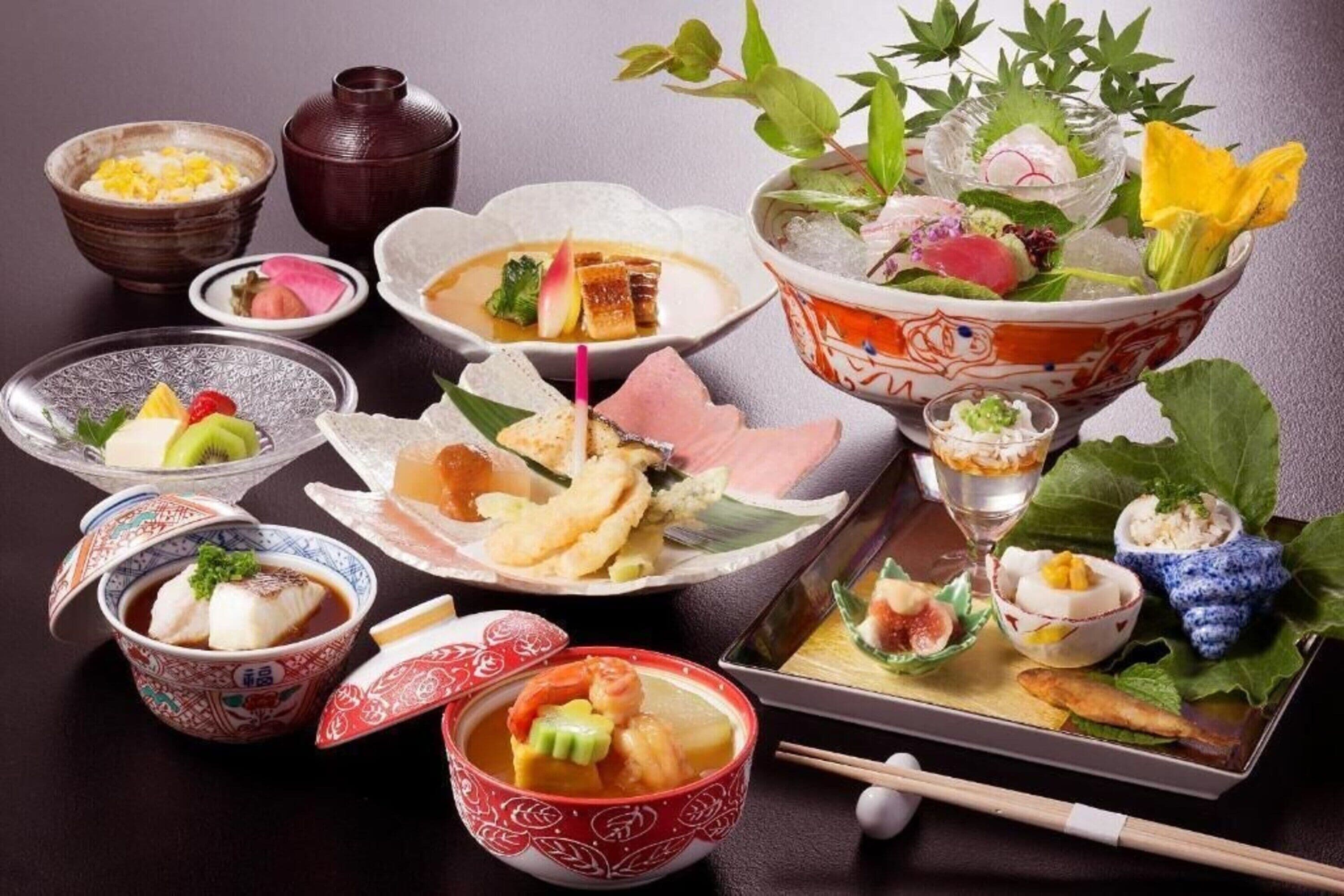 Une variété de plats japonais présentés sur une table, notamment des sushis, des sashimis et d’autres spécialités à base de fruits de mer.