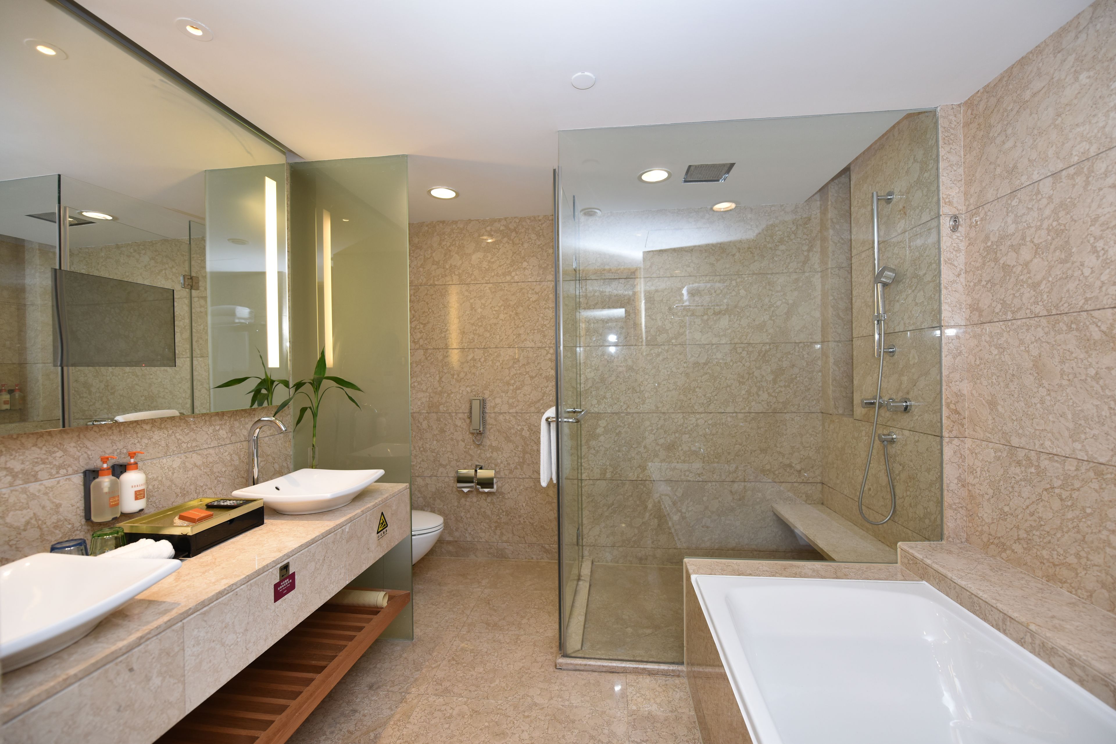 Un baño moderno con ducha de vidrio, bañera independiente y tocador con espejo.