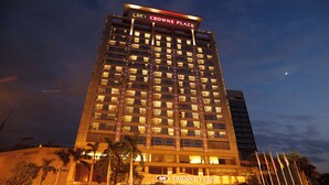 A high-rise hotel with illuminated windows and a prominent sign reading "CROWNE PLAZA".