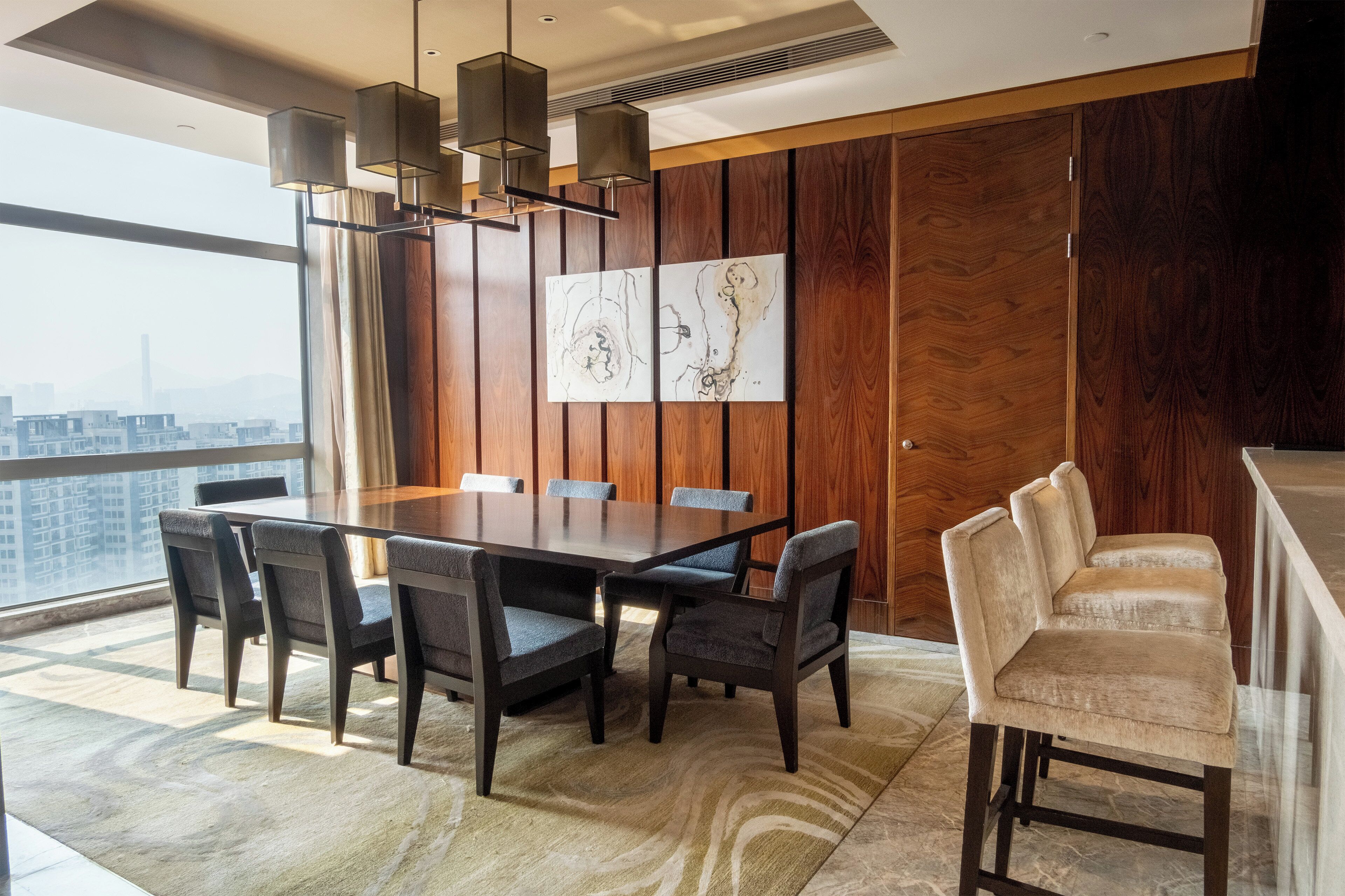 Un comedor moderno con una mesa grande, seis sillas y un banco.