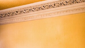 A dining area with a fireplace, a mirror, and a vase with branches. - Strathallan Guest House (Edinburgh)