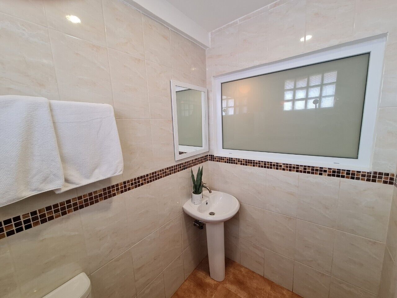 A bathroom with a white sink, a mirror, and a towel rack.