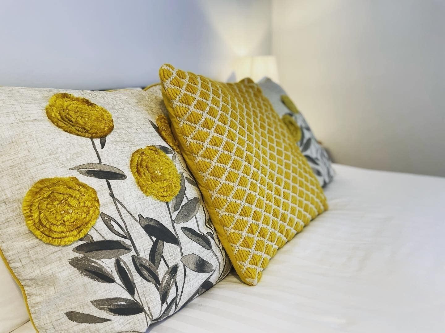 Deux oreillers ornés de motifs floraux sur un lit.
