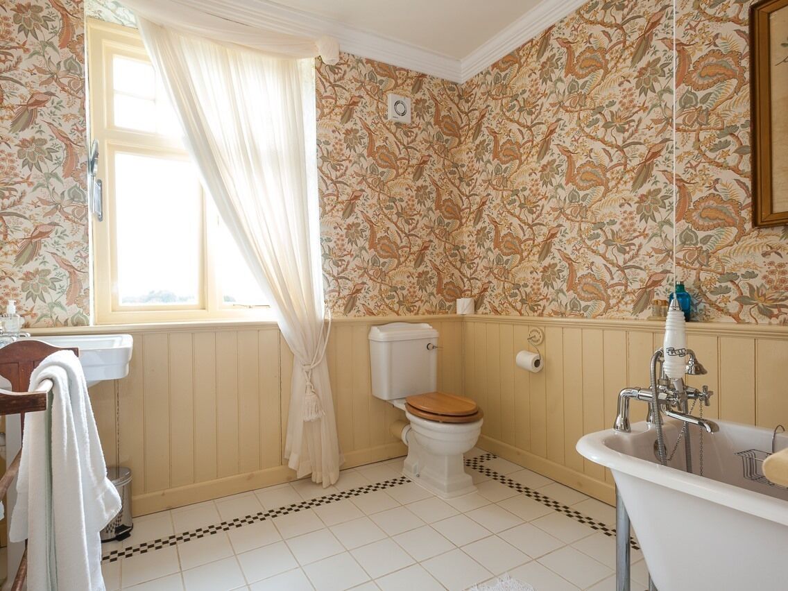 A bathroom with a toilet, sink, and bathtub.