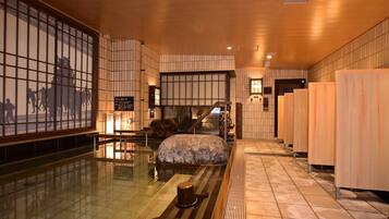 Ein traditionelles japanisches Bad mit Tatami-Boden, einem Steinbecken und Holztüren.