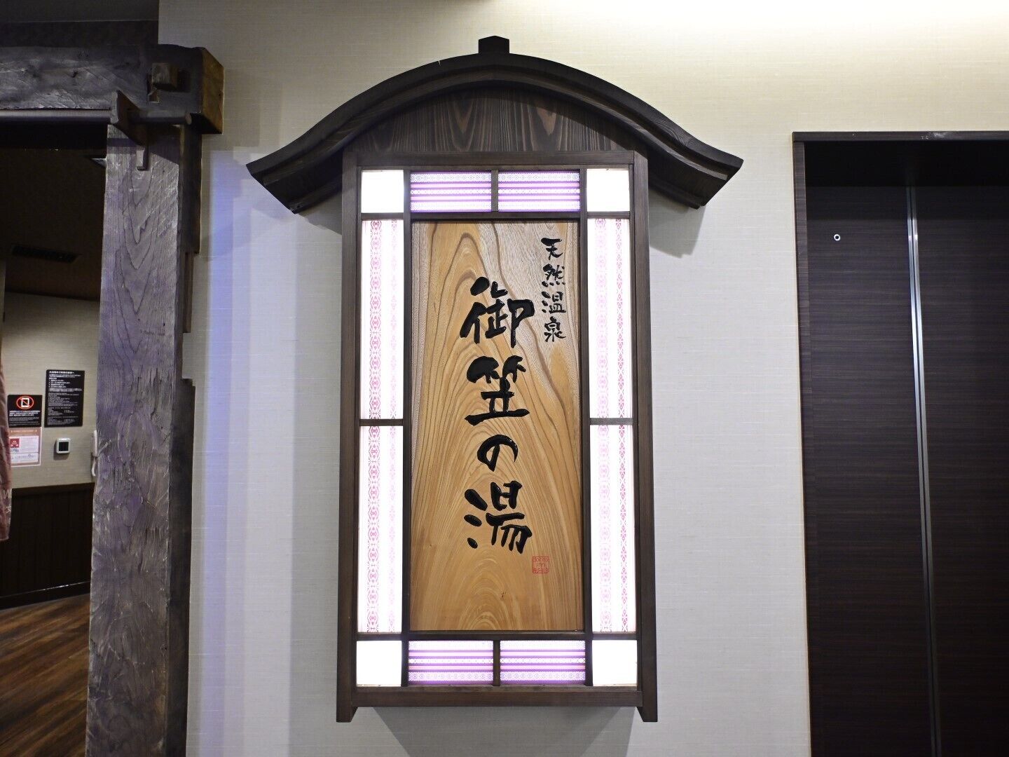 A traditional Japanese-style room with a wooden sliding door and a shoji screen with calligraphy.