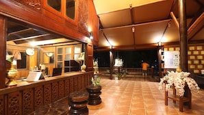 A restaurant with a wooden bar, tiled floor, and a covered outdoor seating area. - Koh Talu Island Resort (Bang Saphan Noi)