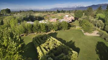 Un campo de golf con un gran césped, árboles y edificios al fondo.