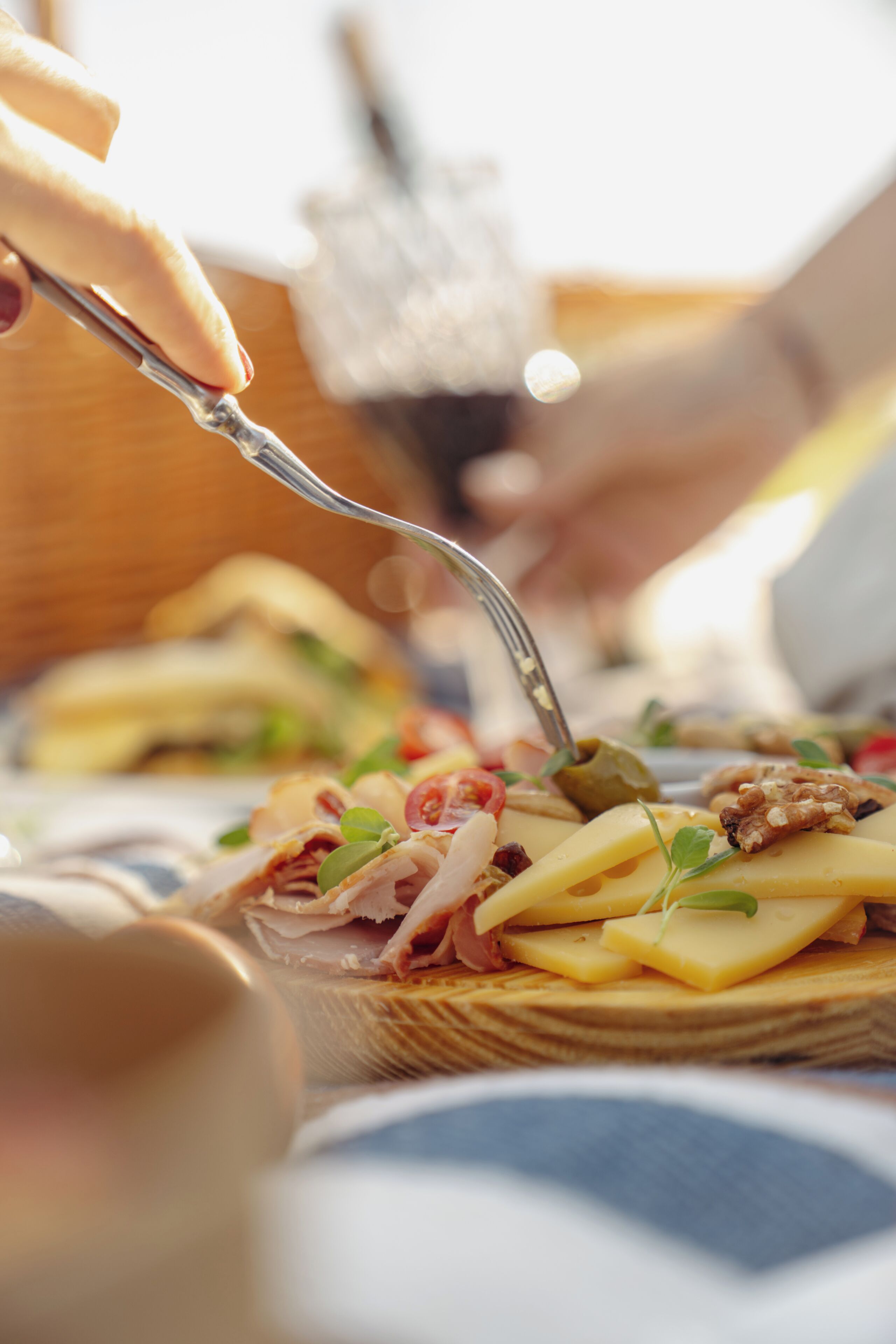 Primer plano de un alimento con un tenedor, posiblemente un sándwich o aperitivo, mostrando ingredientes como queso, nueces y vegetales.