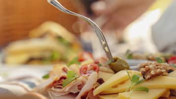 Primer plano de un alimento con un tenedor, posiblemente un sándwich o aperitivo, mostrando ingredientes como queso, nueces y vegetales.