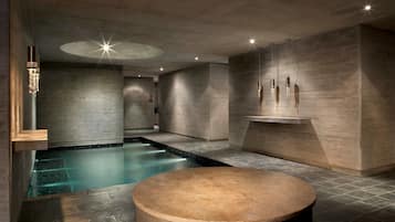 Relax by the serene pool surrounded by geometric design and natural stone.