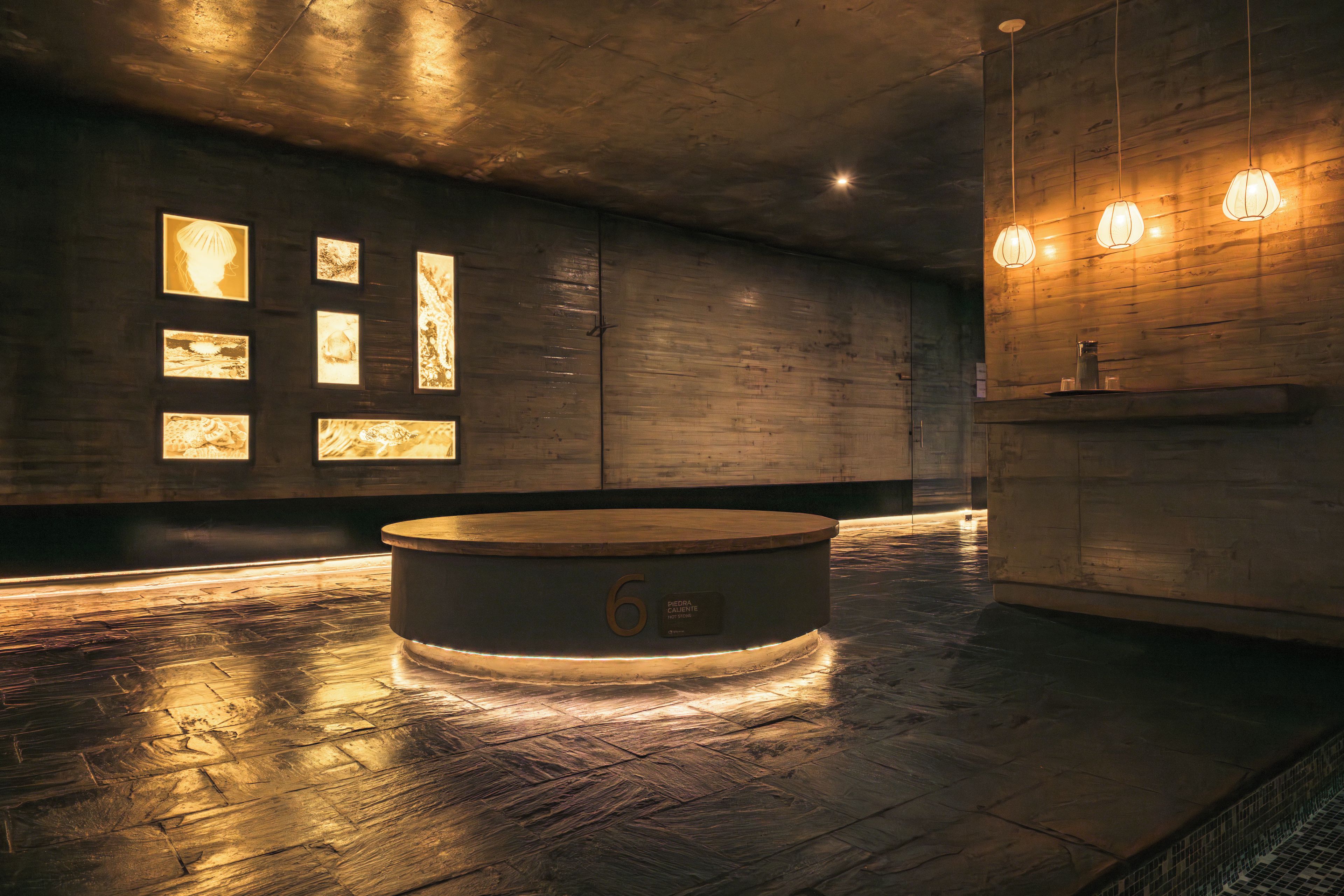 A modern bathroom with a circular bathtub, wooden walls, and framed artwork.