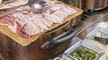 Una cocina con una parrilla, ollas y recipientes de condimentos.