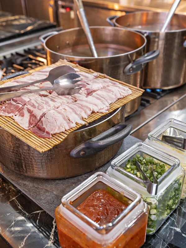 A kitchen with a grill, pots, and containers of condiments. - Farglory Hotel Hualien (Shoufeng)