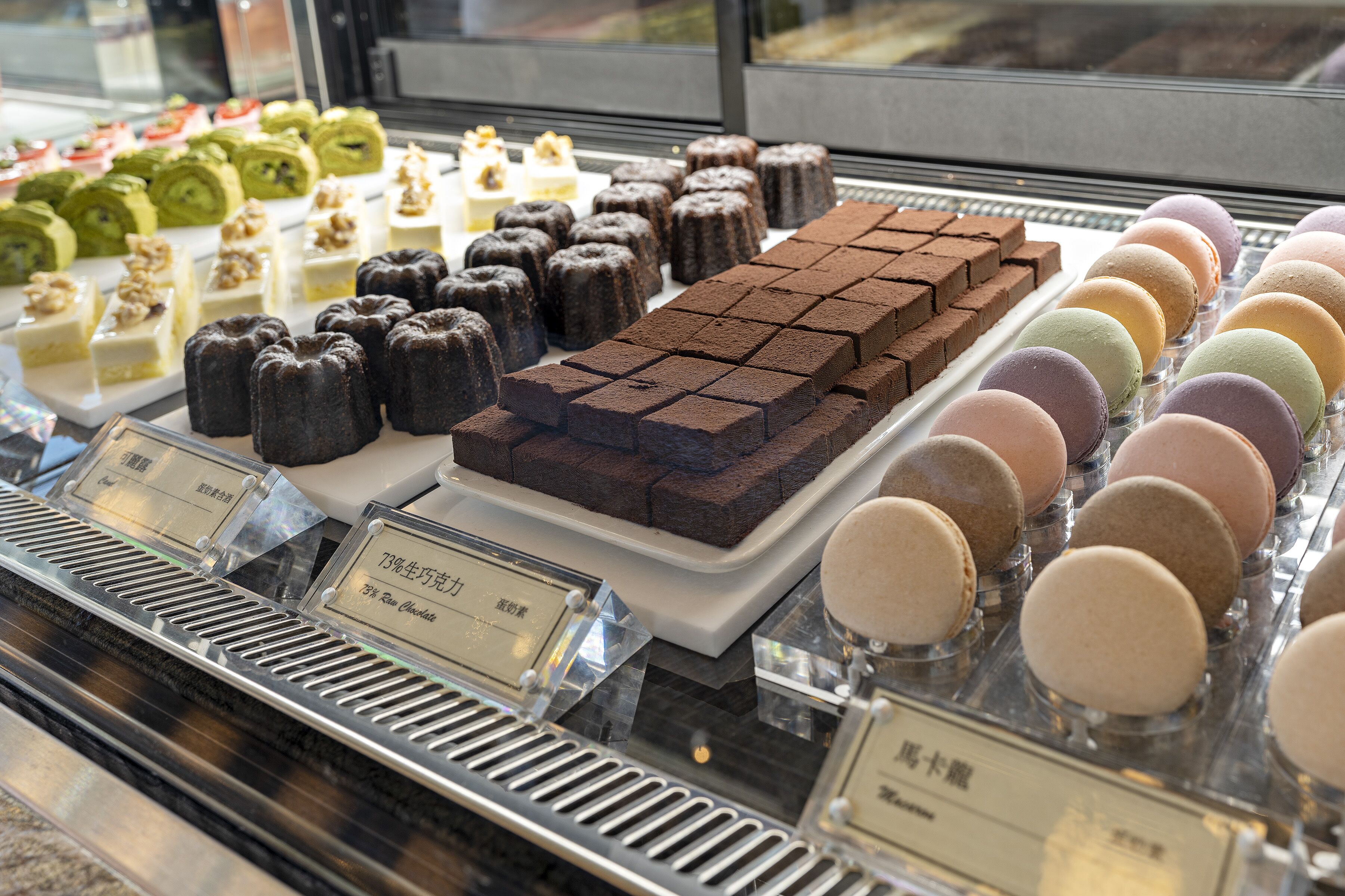 A display of various pastries and desserts in a bakery or cafe.