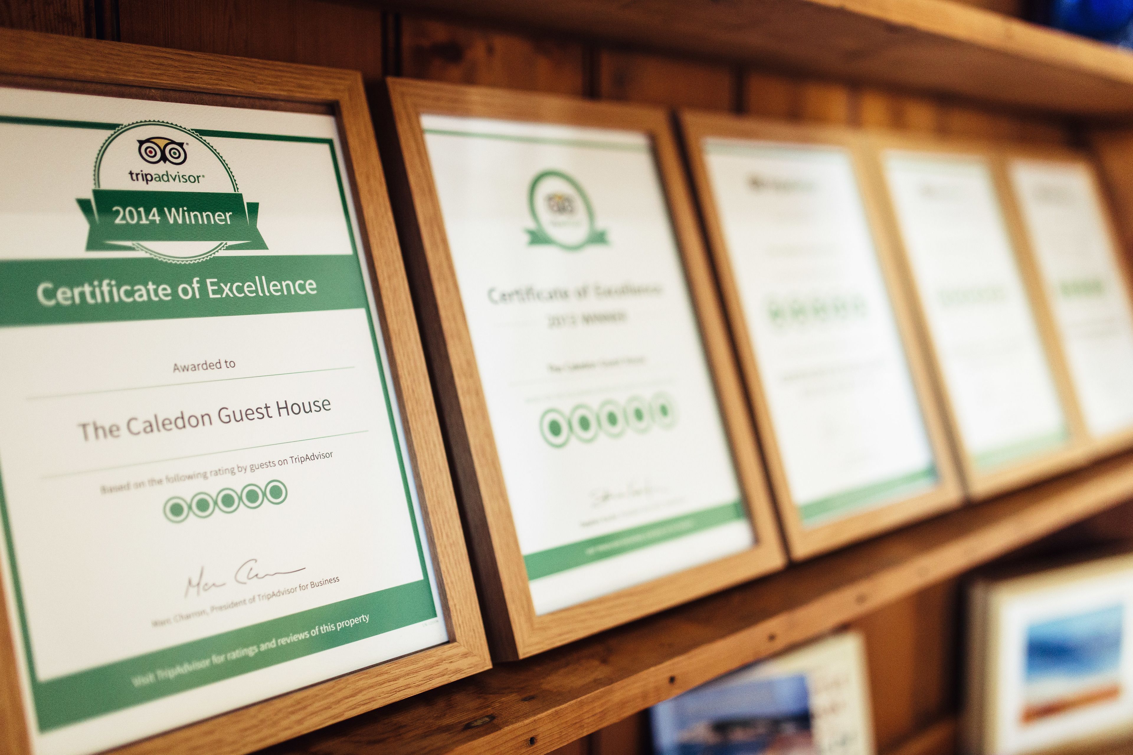 Framed TripAdvisor certificates of excellence for The Caledon Guest House.