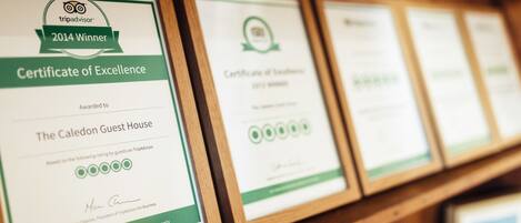 Framed TripAdvisor certificates of excellence for The Caledon Guest House.