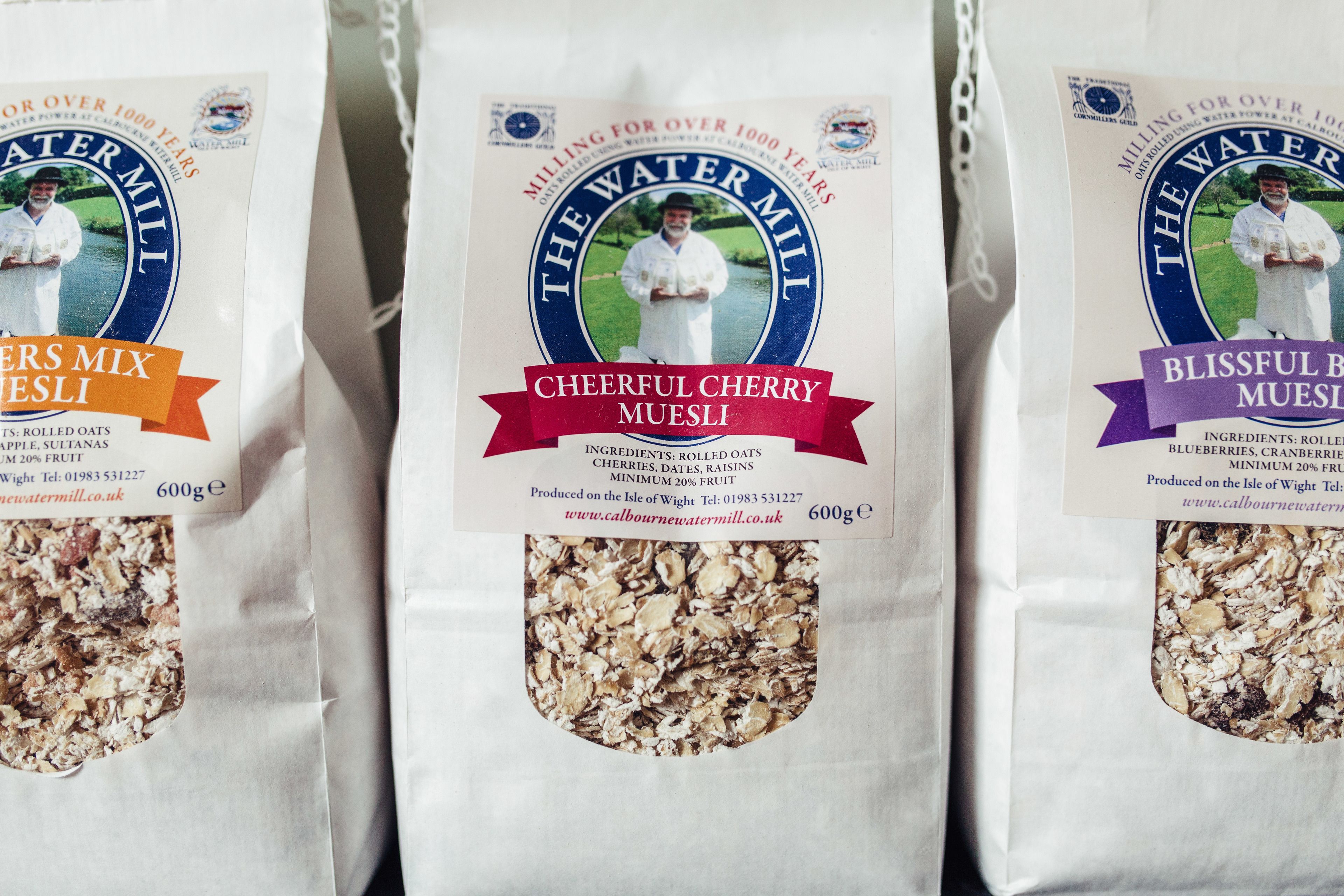Three bags of Cheerful Cherry Muesli from The Water Mill. Each bag contains 600g of rolled oats, dates, raisins, cherries, and a minimum of 20% fruit.