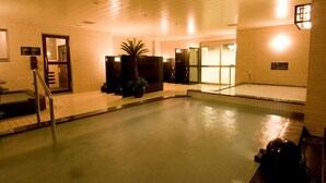 An indoor swimming pool with tiled walls, a palm tree, and a staircase leading to a door. - Dormy Inn Nagasaki Shinchi Chinatown Hot Spring (Nagasaki)