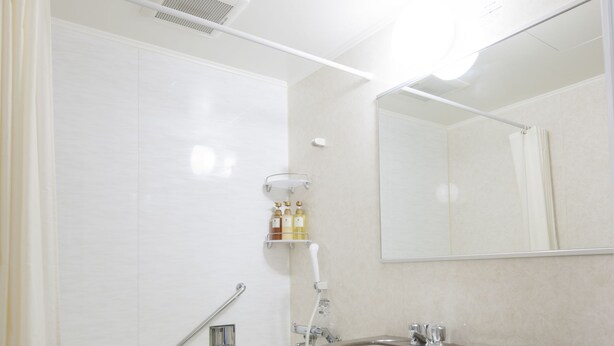 A modern bathroom with a bathtub, toilet, sink, and a shower area. - Dormy Inn Tsu Natural Hot Spring (Tsu)