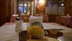 A breakfast setting with a plate of food, a glass of orange juice, and a cup of tea.
