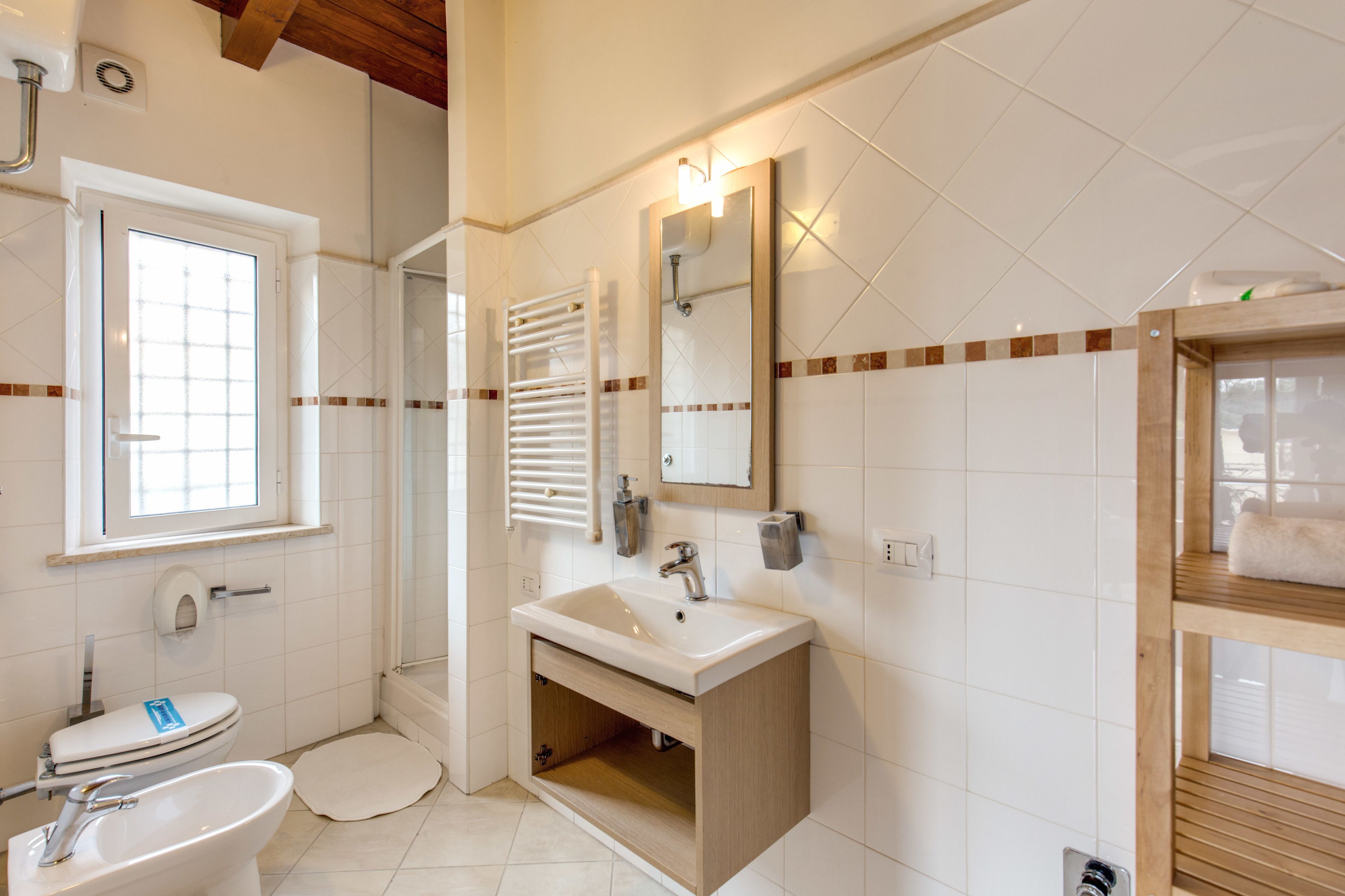 Un baño con inodoro, lavamanos y espejo.