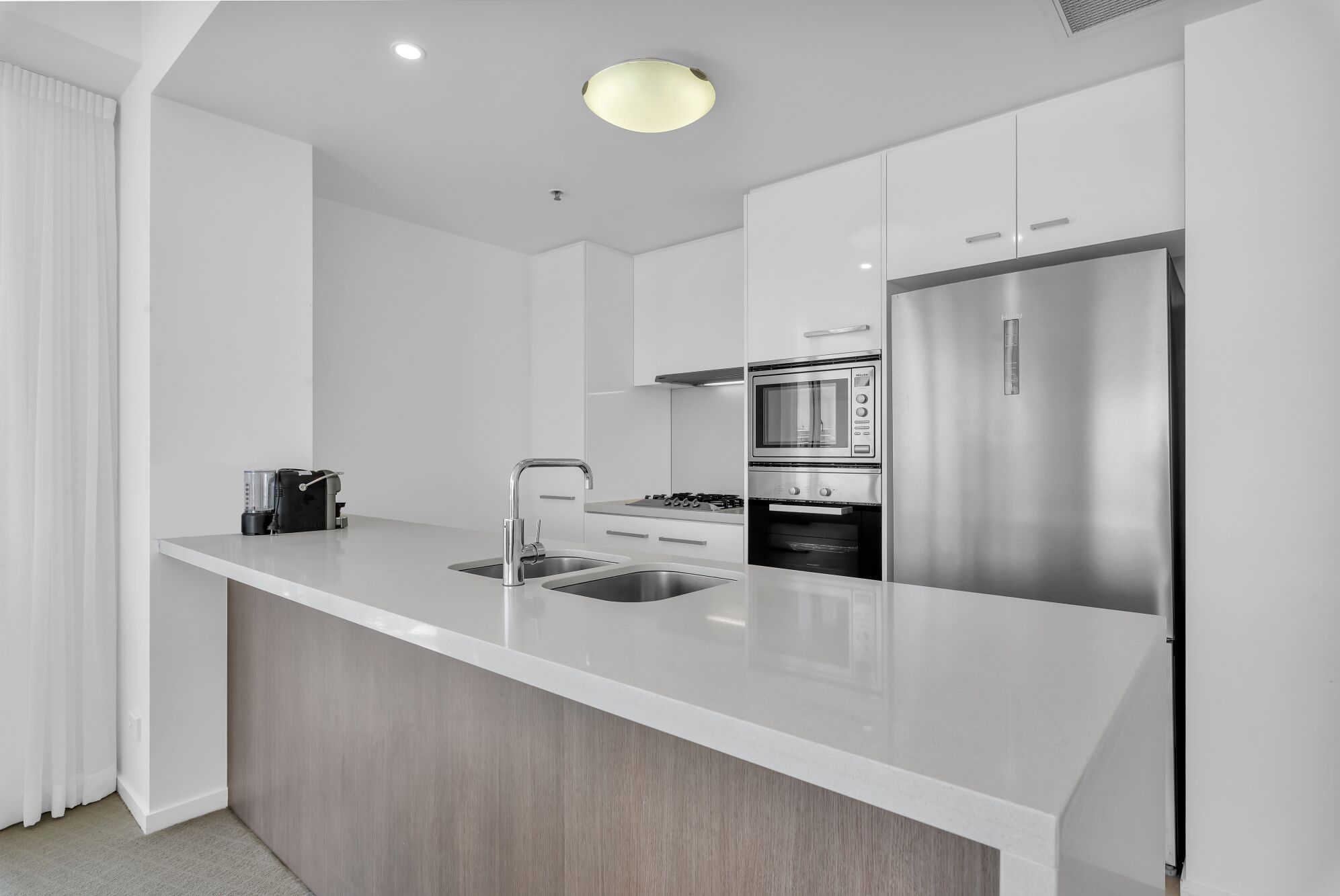 A modern kitchen with a large island, stainless steel appliances, and a sleek design.