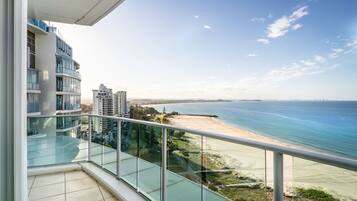 A balcony with a clear view of a beach and ocean.