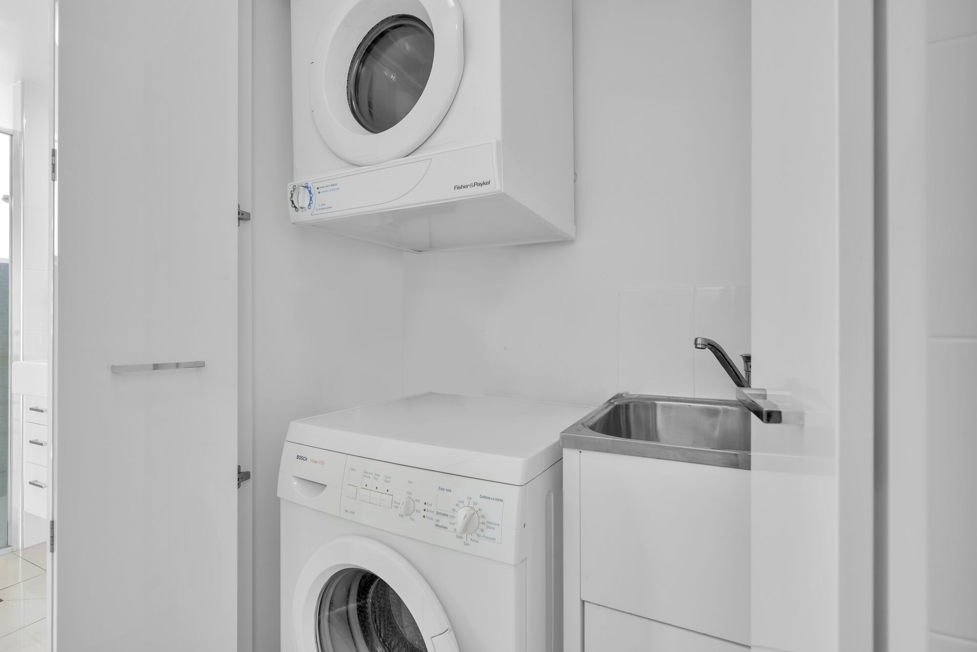 A compact, modern laundry room with a Bosch washing machine and a sink.