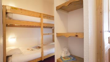 Sleep comfortably in this cozy room with a bunk bed for two, featuring a simple design and ample storage.