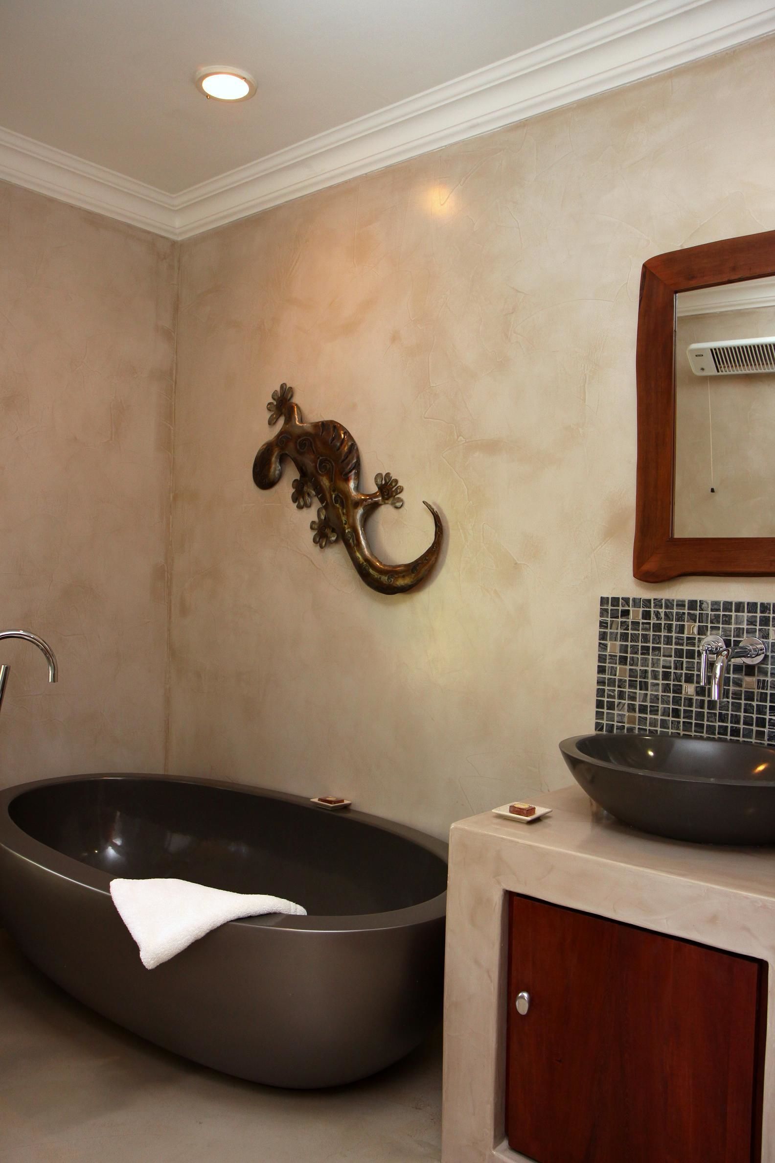 Ein Badezimmer mit freistehender Badewanne, einem Waschbecken und einem Spiegel.