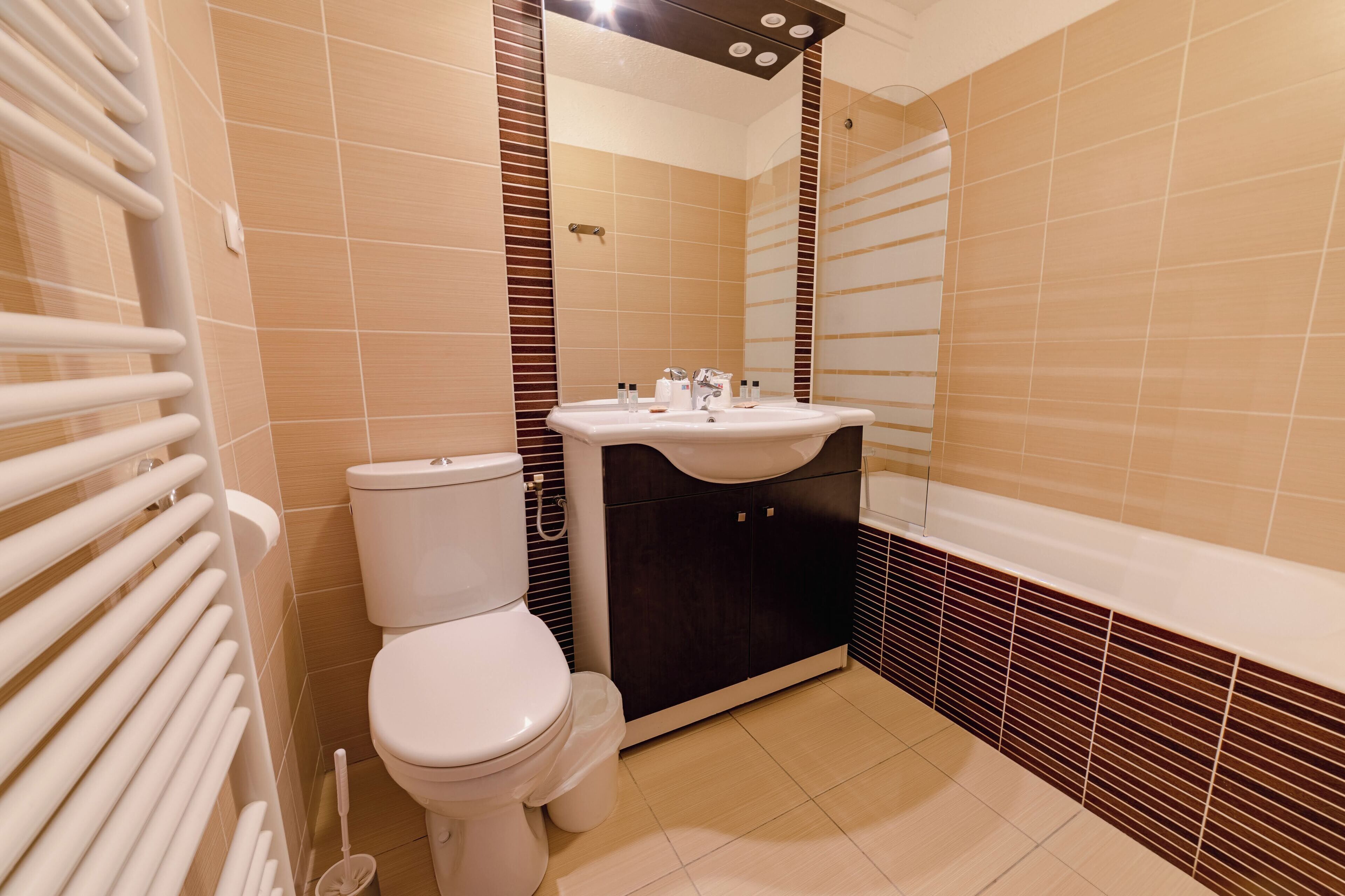 Une salle de bain avec des toilettes, un lavabo et une baignoire.