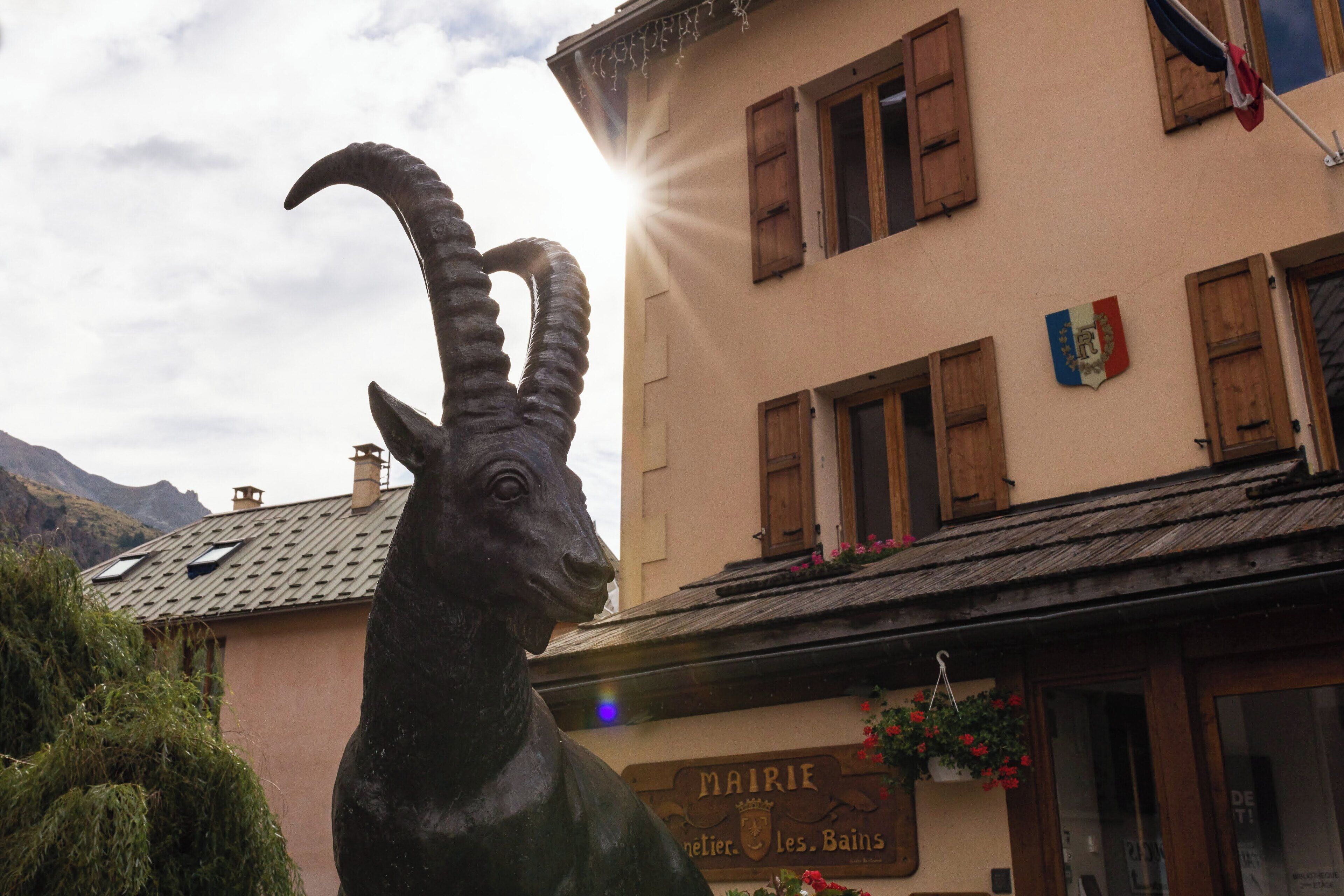 A mountain goat statue in front of a building with a sign reading "MAIRIE".