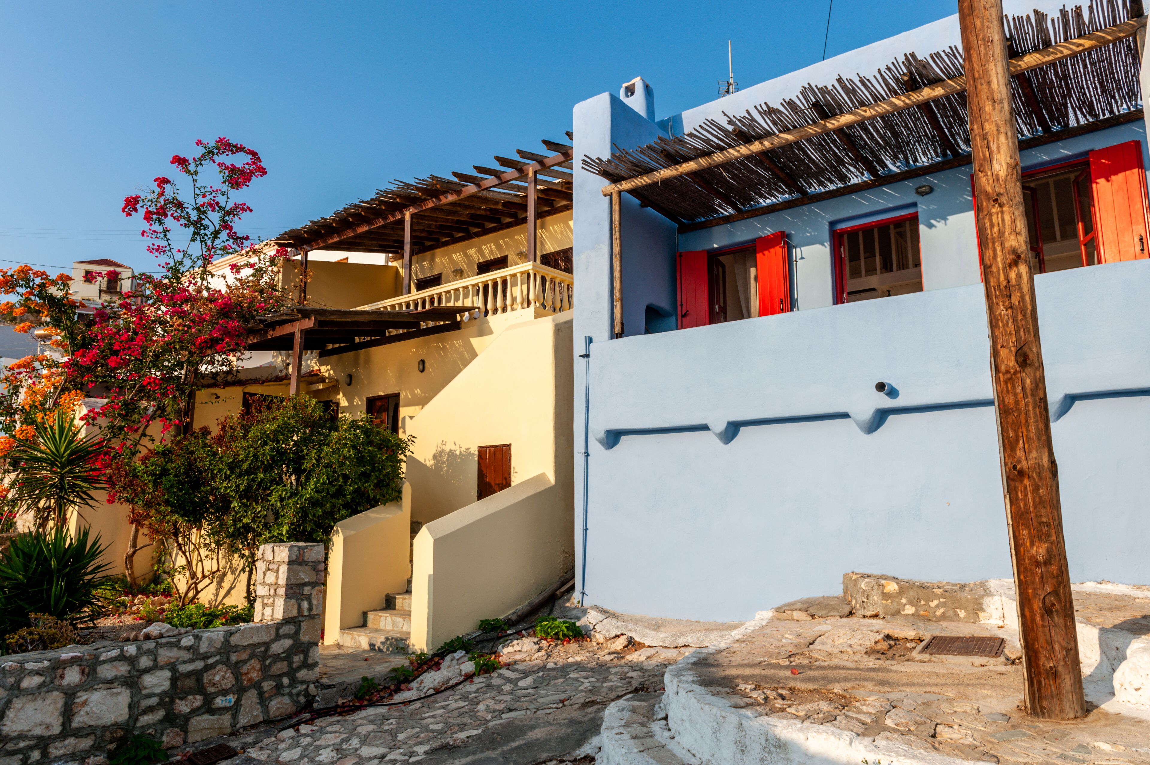 Um edifício tradicional em estilo mediterrâneo com uma escadaria de pedra que dá para uma varanda de madeira.