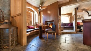 Ein gemütliches Interieur mit Kamin aus Stein, Holzmöbeln und Steinböden.