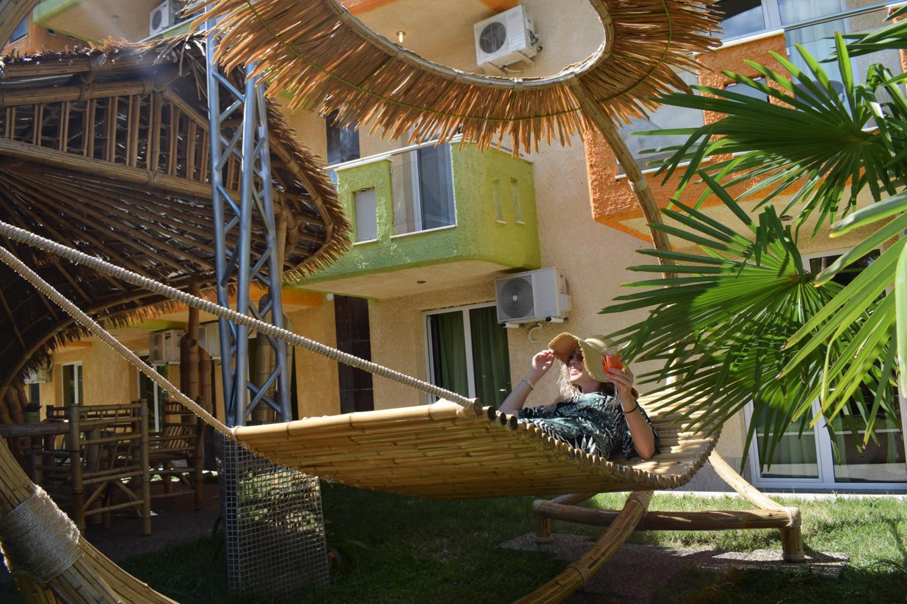 A hammock in a courtyard with a building in the background.