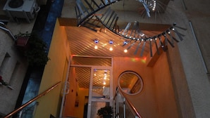 Un escalier doté d’une rampe en métal en forme de spirale et d’un miroir rond fixé au mur.