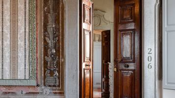 Um corredor com decorações elaboradas nas paredes e uma porta de madeira com o número 206.