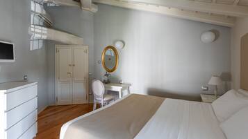 Un dormitorio con cama, escritorio, silla, armario y espejo.