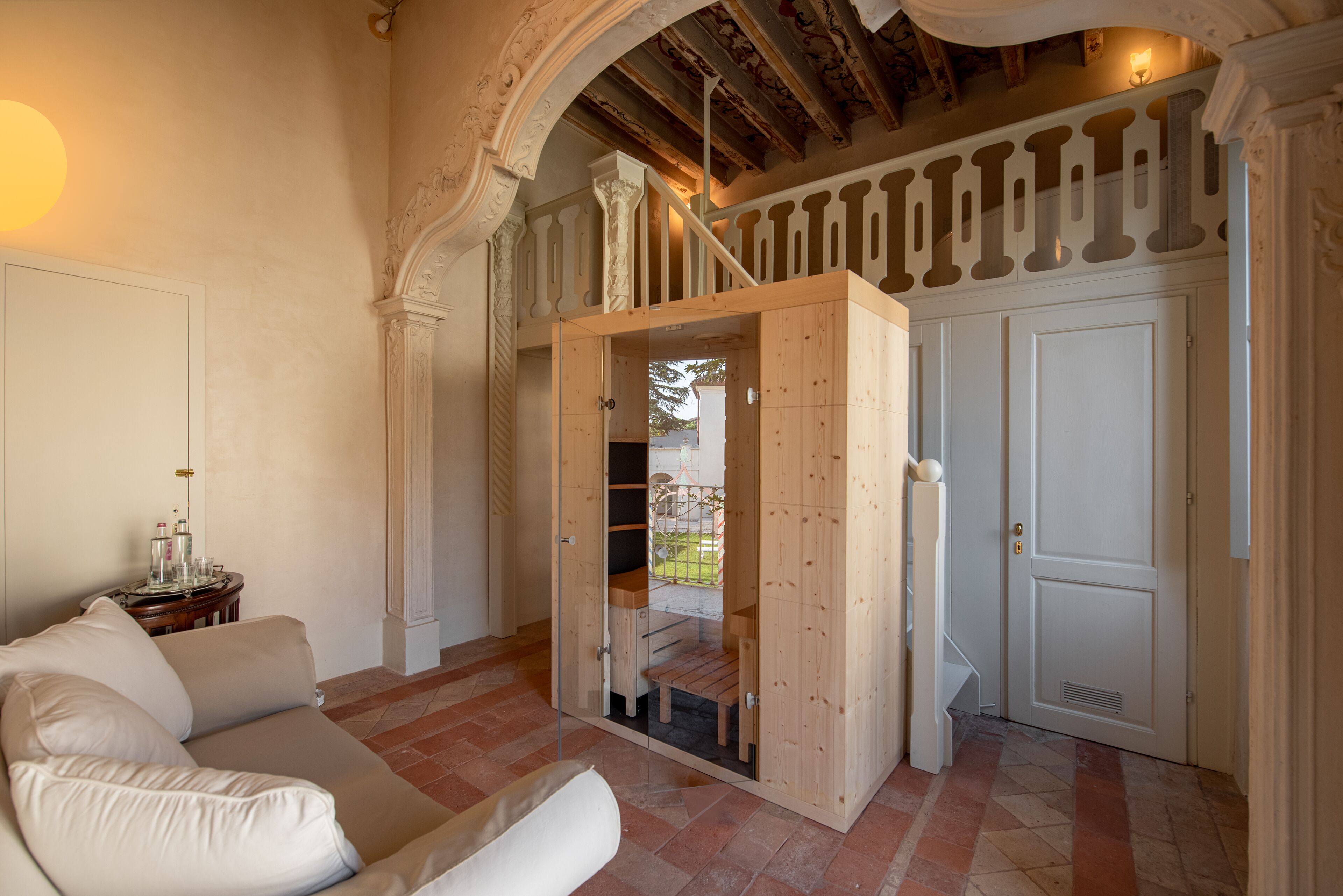 Un salon spacieux avec un canapé beige, un meuble en bois et un escalier menant à l’étage supérieur.