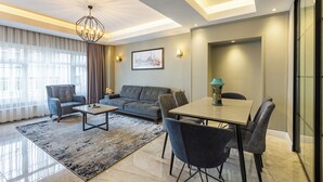 Una sala moderna con un sofá, sillas, una mesa de centro y una mesa de comedor.