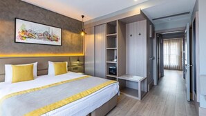 Habitación de hotel moderna con una cama grande, armario empotrado y un cuadro de un paisaje urbano en la pared.