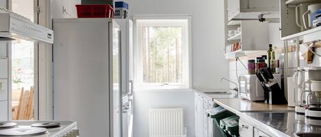 Una cocina moderna con armarios blancos, horno integrado y ventana que proporciona luz natural.