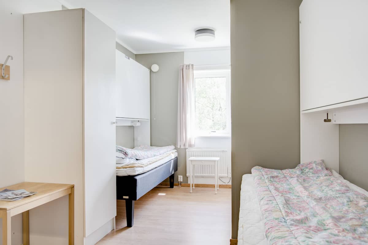 Ein Schlafzimmer mit Bett, Schreibtisch und Heizkörper.