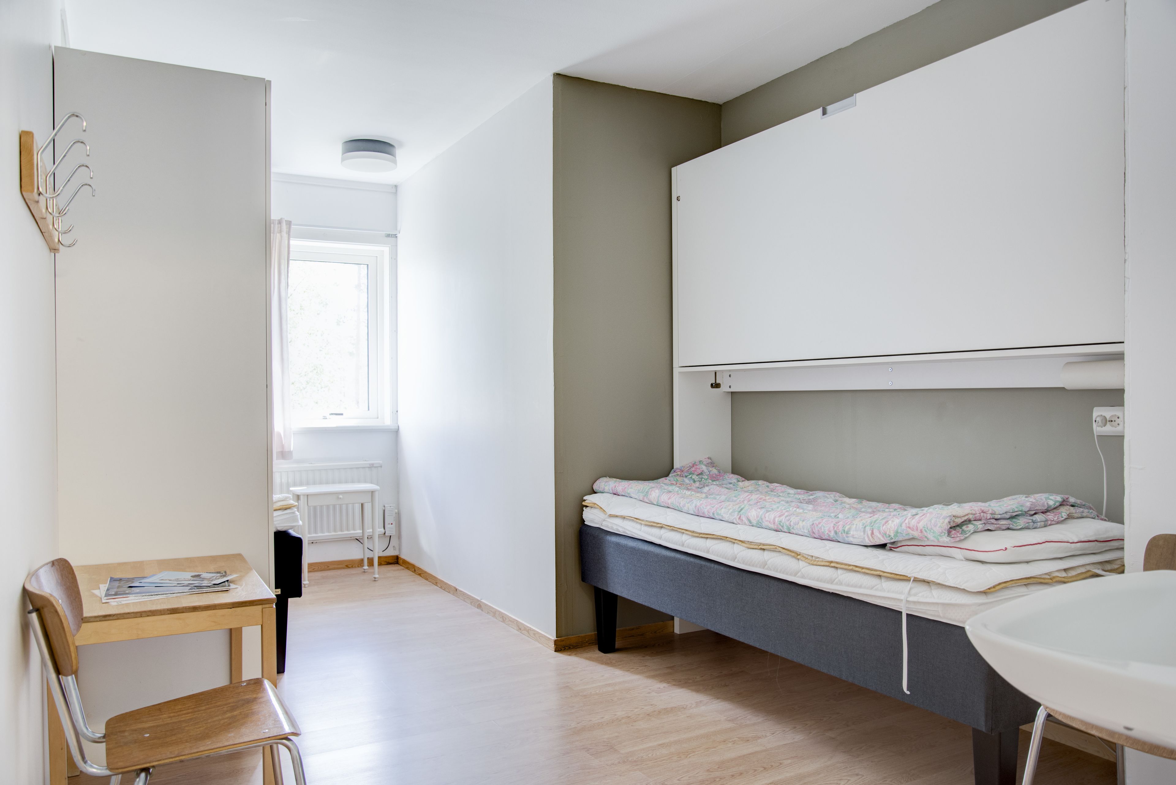 Una habitación con cama, escritorio y silla.