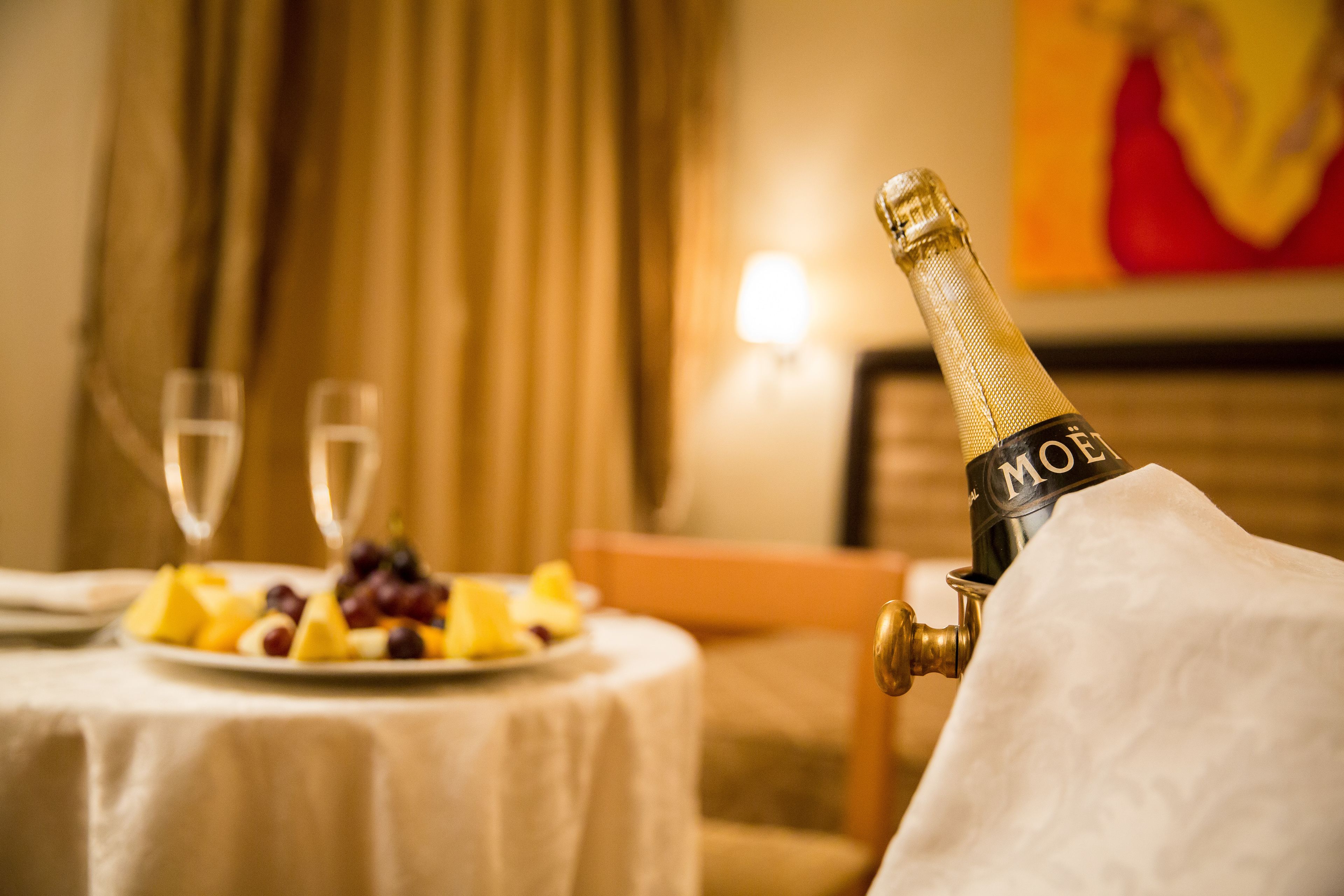 A bottle of Moët champagne on a table with a plate of fruit and two glasses.
